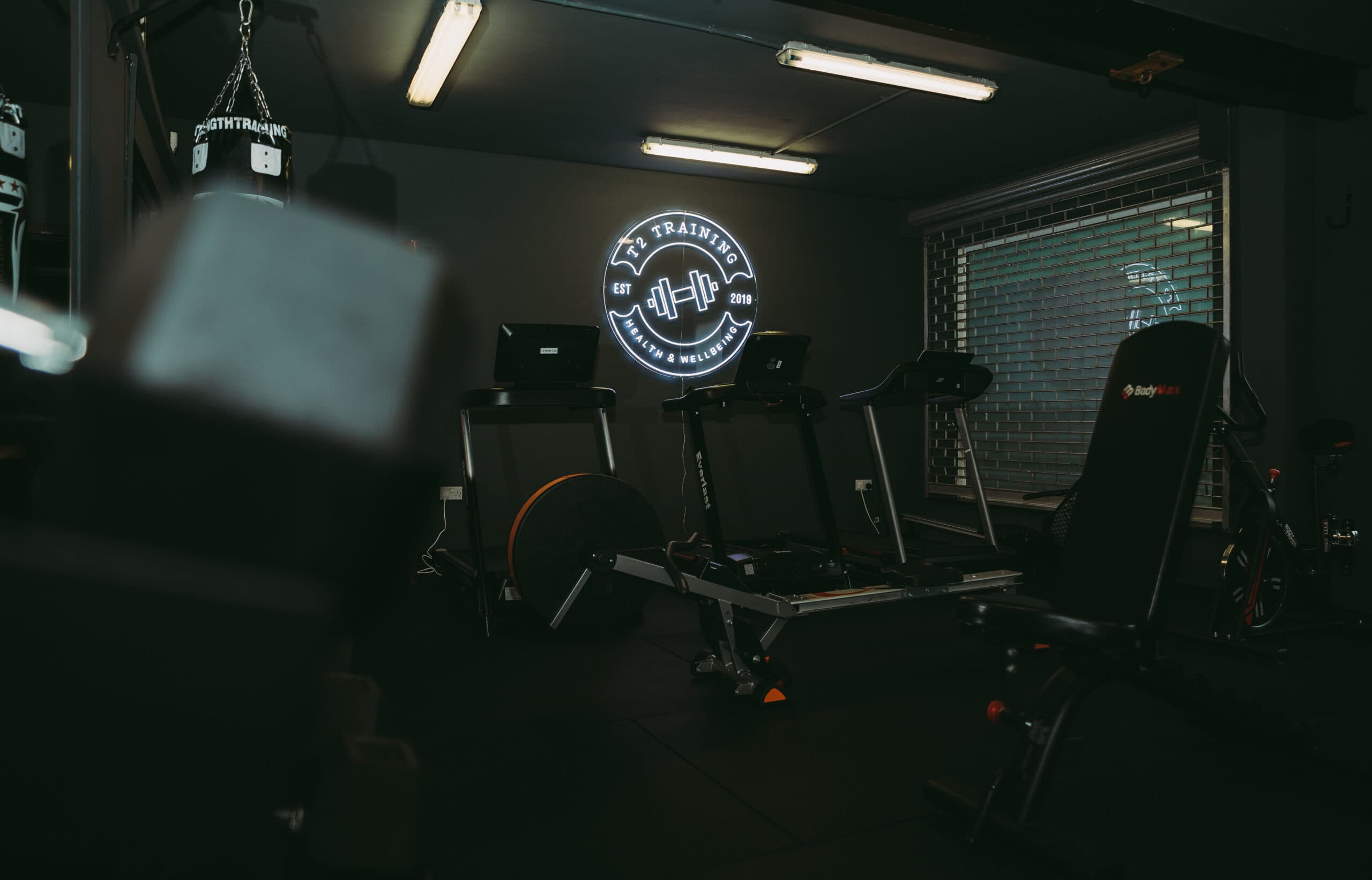 T2 gym interior with neon sign in background